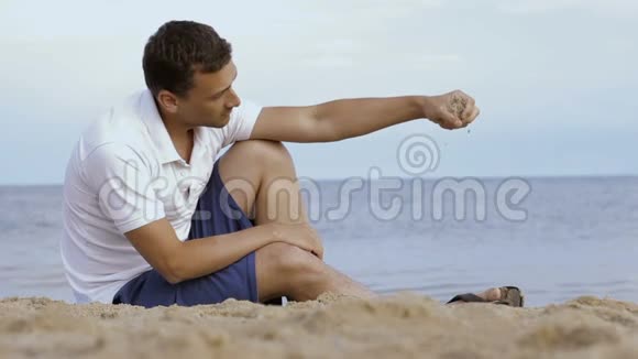 年轻人用手指在沙滩上撒沙视频的预览图