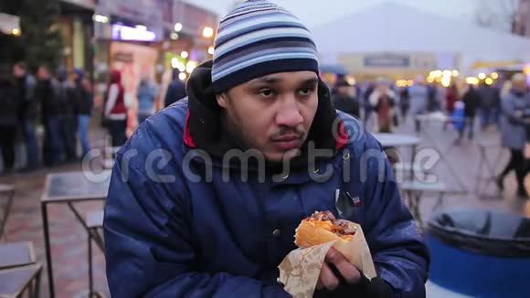 无家可归饥饿的家伙吃热狗慈善垃圾食品胆固醇肥胖视频的预览图