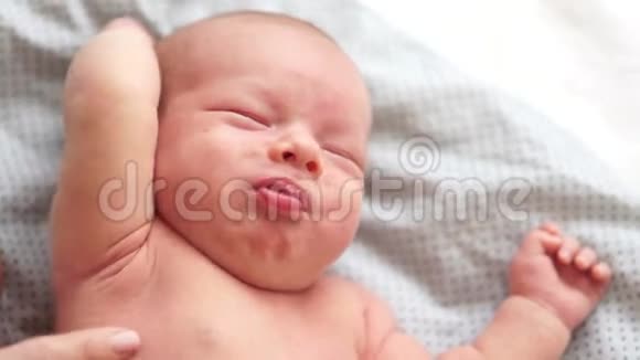在床上哭泣的新生婴儿的特写肖像一个两周大的婴儿从绞痛中醒来新生儿的梦想视频的预览图