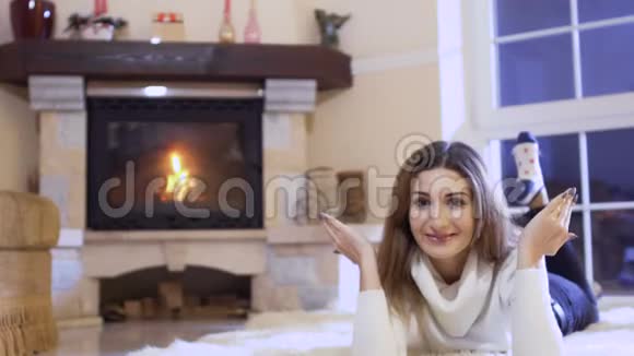 小女孩躺在壁炉旁的地板上改变她的情绪视频的预览图