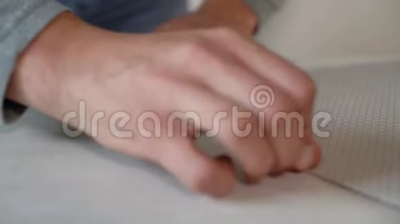 在室内桌上用信纸刀准备新的弯曲壁纸辊视频的预览图