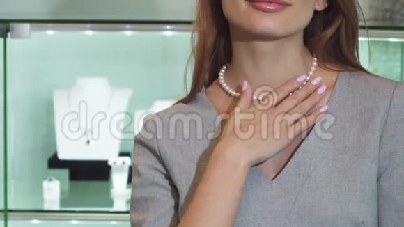 一位戴着珍珠项链微笑的幸福女人视频的预览图