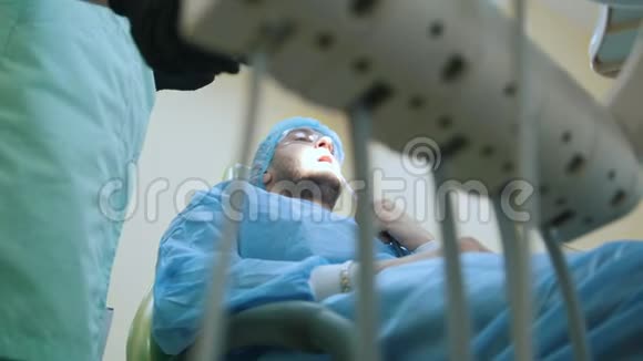 医生和病人在牙科办公室治疗过程设备在前台视频的预览图