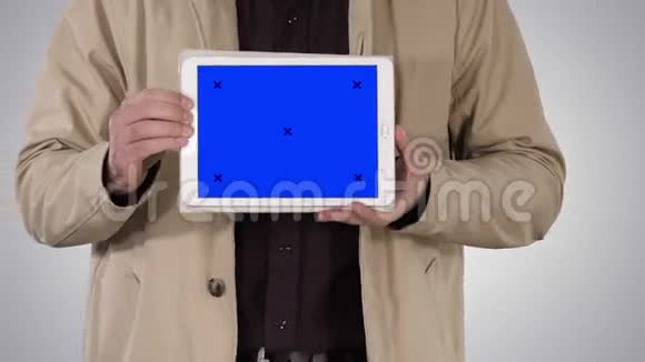 男性手拿平板电脑与蓝色屏幕模型在梯度背景视频的预览图
