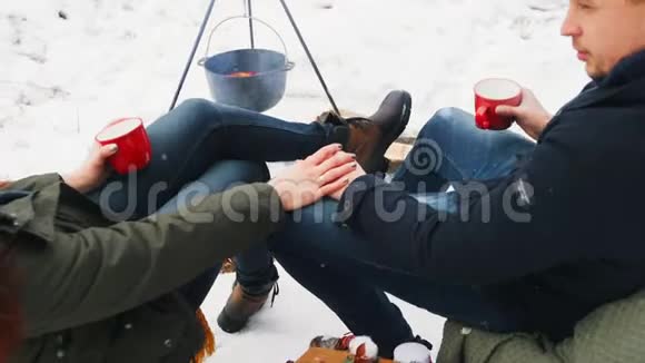一对夫妇坐在火边手牵着手冬天的爱视频的预览图