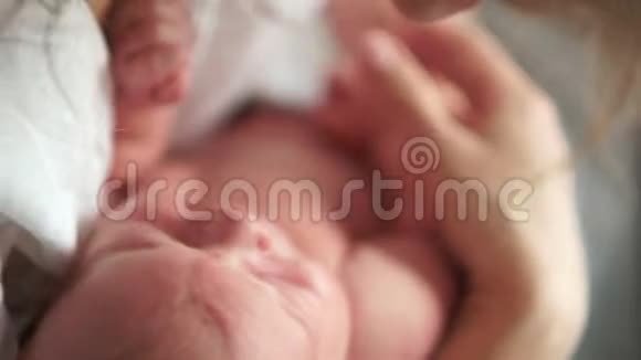 一个新生婴儿睡在母亲的怀里母亲节母亲轻轻地平静下来抱着她的孩子从一边到另一边摆动视频的预览图