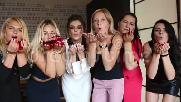 时尚女性在酒店玩得开心在镜头前吹红纸屑视频的预览图