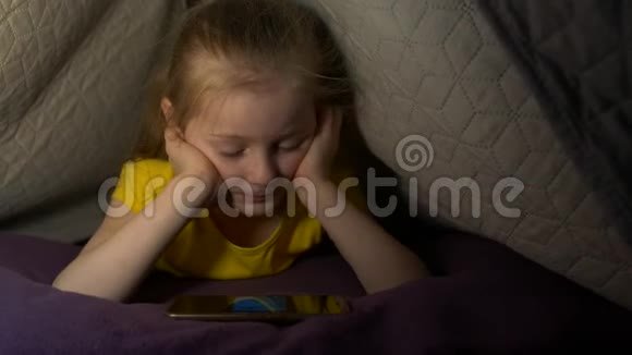 床上有电话的小女孩视频的预览图