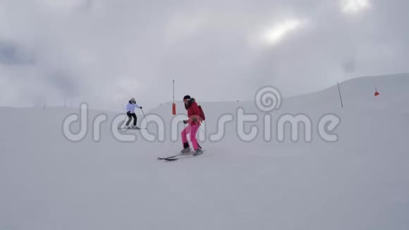 两名女子滑雪者在浓雾下坡的困难山上滑雪视频的预览图