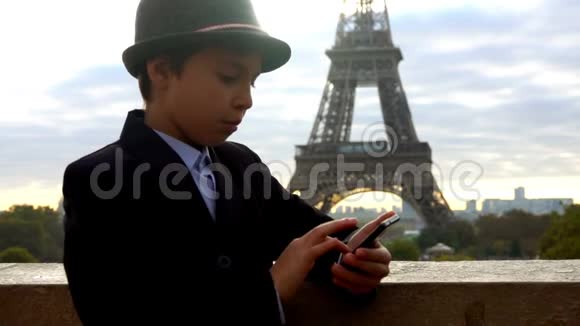 戴帽子的男孩在智能手机上写信息视频的预览图