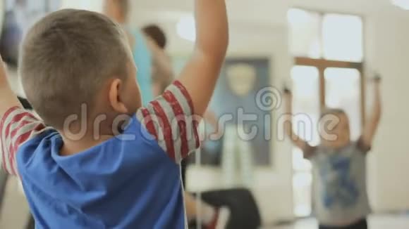 孩子把哑铃举到健身房的镜子上视频的预览图