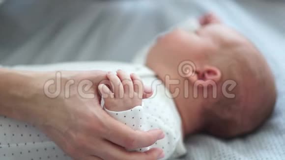 妈妈轻轻地抚摸她新生婴儿的手皮肤到皮肤上快乐的母亲视频的预览图