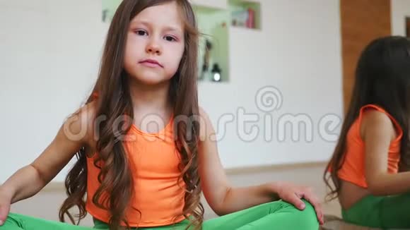 女孩正坐在莲花的位置上在健身房关门视频的预览图
