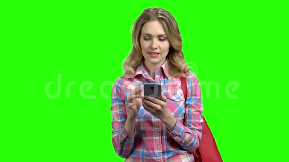 女人在绿色屏幕上使用手机视频的预览图