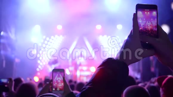 摇滚假日一群人拿着手机拍着音乐艺术家上台视频的预览图