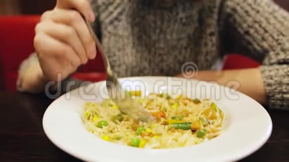 年轻的白种人女孩坐在餐馆里吃着热腾腾的泰国米饭视频的预览图