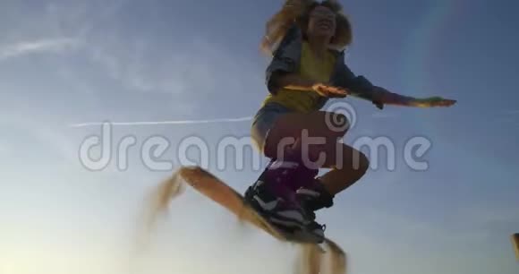 运动缓慢年轻漂亮的女孩穿短裤的嬉皮士运动员试着在沙丘上玩滑板砂板视频的预览图