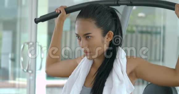 亚洲女孩健身器在健身房里使用举重机视频的预览图
