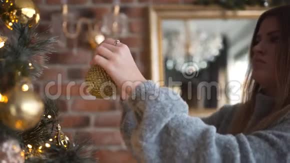 年轻迷人的高加索女人用金球圣诞夜圣诞安排花环和视频的预览图