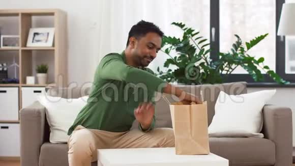 微笑的印度男人在家解外卖视频的预览图