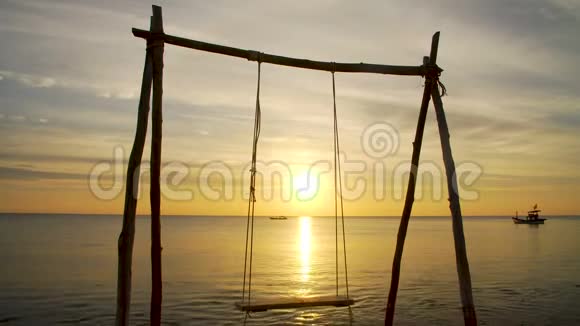 日落时摇摆的热带海滩视频的预览图
