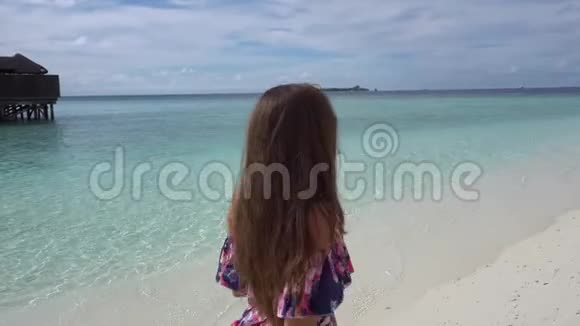 快乐的女人在马尔代夫的海边散步微笑和欢乐视频的预览图