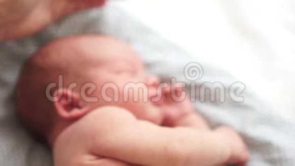 妈妈轻轻地抚摸她刚出生的婴儿的头孩子睡觉移动把手皮肤接触视频的预览图