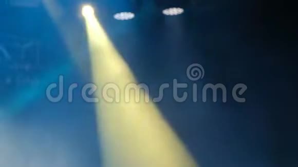 在岩石音乐会现场的烟雾中闪烁着蓝色和黄色的光模糊的背景录像视频的预览图