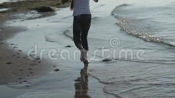 年轻女孩沿着海滩慢动作奔跑视频的预览图