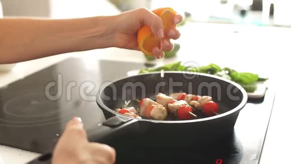 在厨房的煎锅上女性双手捏着橘子的歪视慢动作视频的预览图