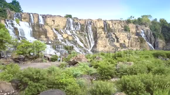 庞古尔瀑布旁的河上岩石茂密的灌木丛视频的预览图