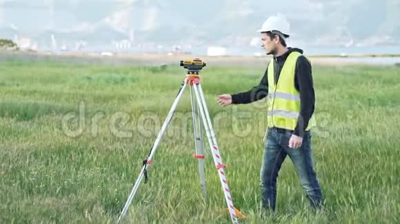 一名穿工作服的男性测量员调整施工现场的设备景观设计大地测量的概念视频的预览图