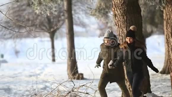 快乐的一对夫妇在寒假期间一起在雪园外面玩他们跑跳视频的预览图