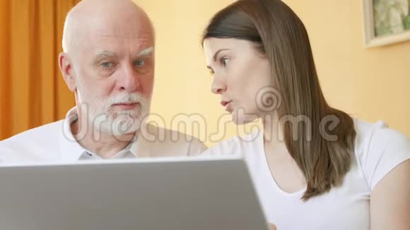 老年父女使用笔记本电脑十几岁的孙女教爷爷如何使用笔记本电脑视频的预览图