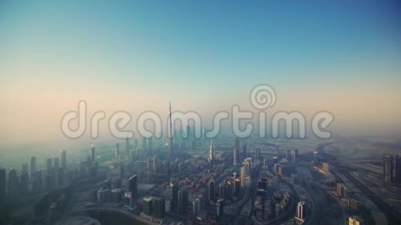 空中无人驾驶飞机在未来的塔楼上飞行巨大的摩天大楼迪拜城渐变的早晨粉红色的雾日出视频的预览图