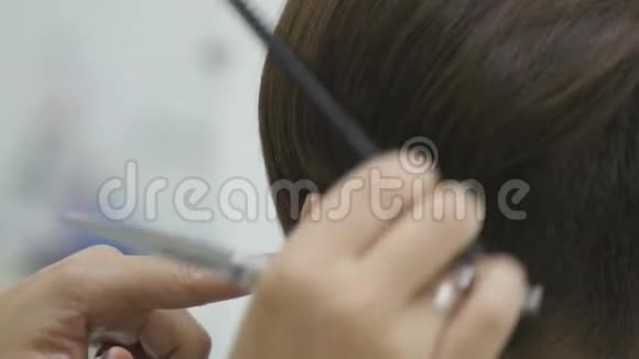 的理发师给她的头发做短发造型视频的预览图