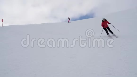 滑雪者在冬季滑雪场的高山下坡滑雪视频的预览图