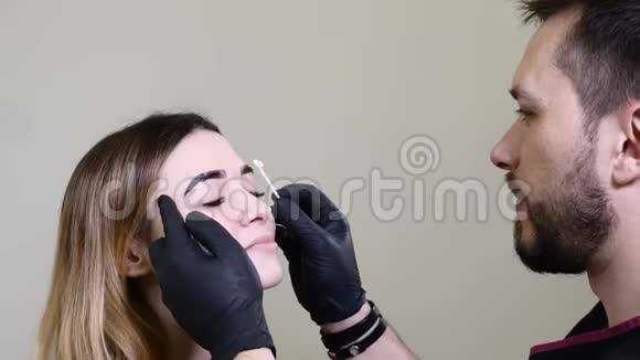 美容师长期化妆专家在眉毛永久化妆前应用局部麻醉剂视频的预览图