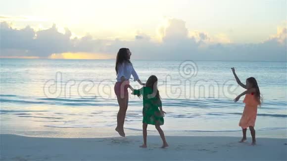 可爱的小女孩和年轻的母亲在白色海滩上玩得很开心流动人口视频的预览图