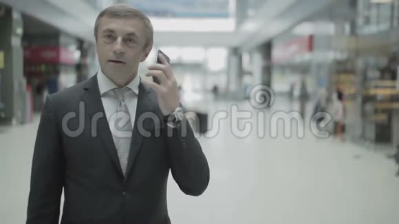 商人打电话带着手提箱离开机场视频的预览图