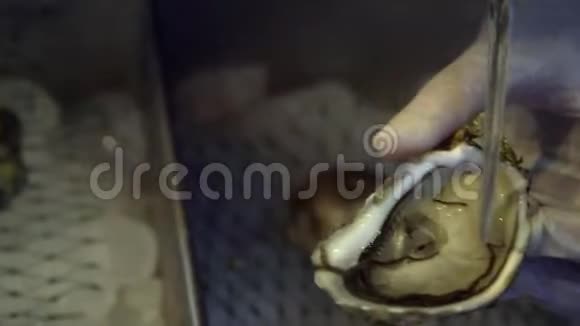 手拿手套在餐厅用刀吸鲜生蚝视频的预览图