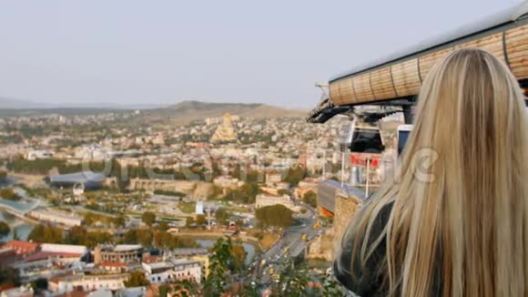 女性拍摄城市全景照片女士用智能手机制作视频的肩部视图第比利斯市视频的预览图