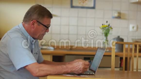 一个成熟的人用笔记本电脑支付账单现代技术和退休年龄人口视频的预览图