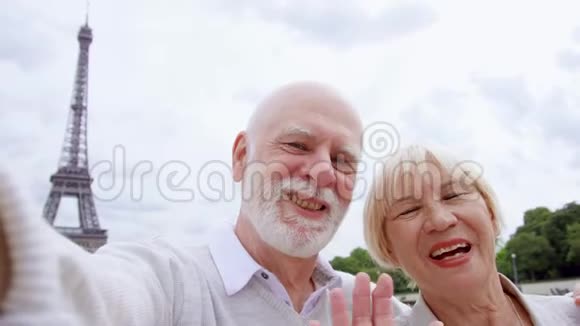 埃菲尔铁塔附近的一对老夫妇在手机上通过信使交谈退休后积极的现代生活视频的预览图