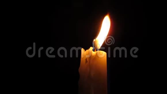 一支蜡烛在黑暗的夜晚燃烧焰在风中摇曳录像视频的预览图