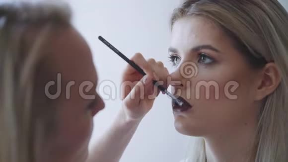一个漂亮女人的肖像口红涂着深色照在镜子里一个漂亮迷人的女孩画视频的预览图