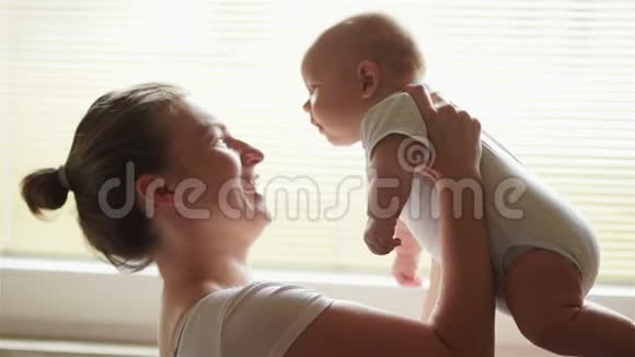 年轻的母亲抱着她新生的孩子妈妈在照顾宝宝女人和新出生的男孩在卧室里放松母亲母乳喂养视频的预览图