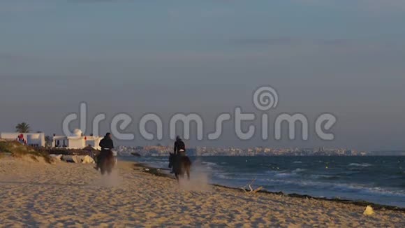 两名骑马者在海滨逃跑后景视频的预览图