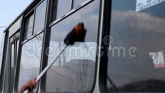 一个人在露天洗一辆脏公共汽车视频的预览图