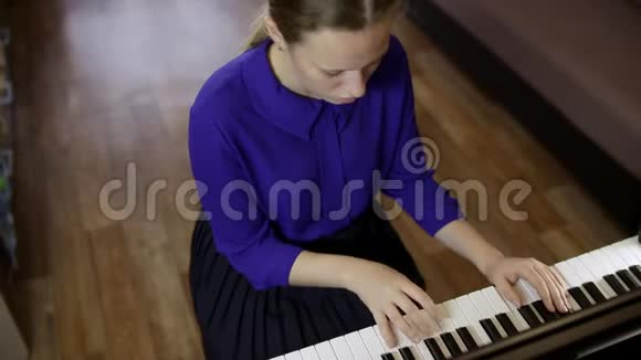 少女在数字钢琴的键盘上弹奏视频的预览图